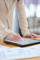 Close-up of hand signing electronic documents on a tablet with a digital pen for online workflows photo