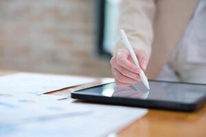 Close-up of hand signing electronic documents on a tablet with a digital pen for online workflows photo
