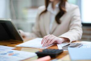 Businesswoman analyzing charts and using a tablet for data review photo
