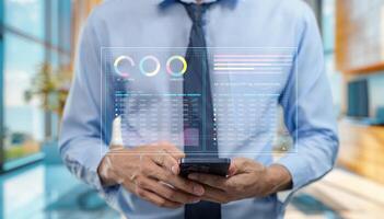 Businessman using smartphone with business data on screen photo