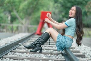A woman in boots sitting on a railroad track photo