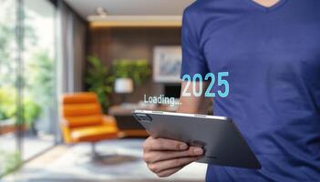 Man holding tablet with 2025 on screen photo