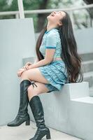 A woman sitting on a ledge with her legs up photo