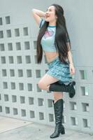 A woman in a blue shirt and black boots posing for a picture photo