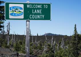 Sign in lava fields marking the boundary of Lane Count Oregon photo