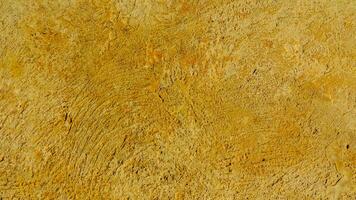A close up of a yellow wall with some paint photo