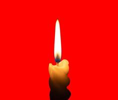 A single burning candle flame or light glowing on a small spiral yellow candle isolated on red background with clipping path photo