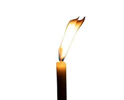 A single burning candle flame or light glowing on a small white candle isolated on white background with clipping path photo