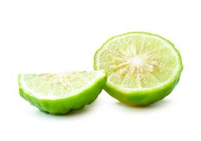 Front view of fresh green bergamot fruits or kaffir lime with half but no green leaf in stack isolated on white background with clipping path photo