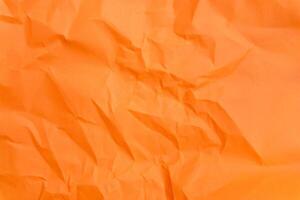 Top view and full frame of wrinkled or crumpled orange paper used as crumpled orange paper background texture. photo