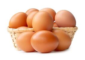 Group of fresh brown chicken eggs in stack in wicker basket isolated on white background with clipping path photo