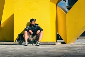 A man sitting on a bench near a yellow sculpture photo