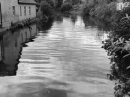 Watercourse with Clouds and Sky Over Nature and Architecture in Daytime photo