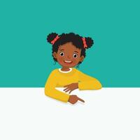 Cute little African girl standing behind blank board peeking and pointing to empty banner with finger vector
