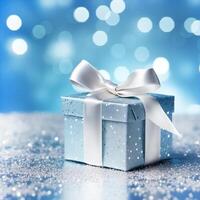 close up of a blue box with glitter packaging wrapped in white ribbon on a surface with silver confetti on a blue background with white bokeh photo