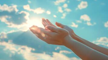 female hands with long nails with minimalist manicure are stretched out against the background of the blue sky in a prayerful or pleading gesture photo