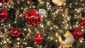 A close-up of a Christmas tree adorned with red ornaments and white lights. The tree is covered in a light dusting of artificial snow, creating a festive and magical atmosphere photo