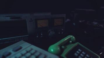 Outdated communication devices arranged on a table in dim lighting video