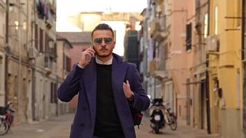 Man talks and puts smartphone into coat pocket on street video