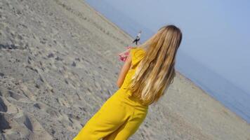Teenager lifts a bunch of flowers from the sand and throws them on the ground video