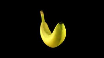 Yellow banana rotates on a black background video