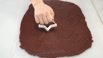 Baker cuts star shapes from raw chocolate dough at table video