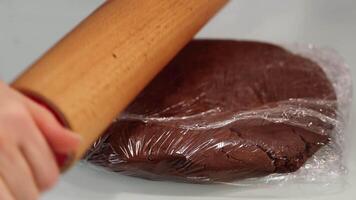 Rolling dough wrapped with foil with pin to cook tasty pie video