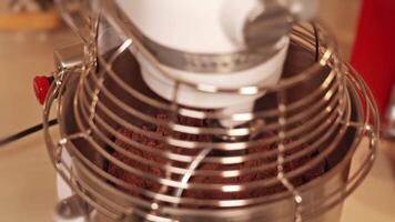Machine kneads chocolate dough for delicious cake on table video