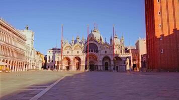 Ancient St Mark Basilica and high red poles on empty square video