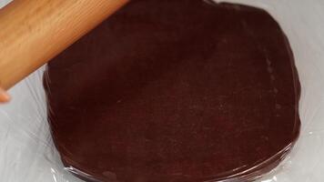 Rolling piece of chocolate dough to cook biscuits on table video