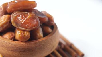 A delectable assortment of Medjool Dates arranged in a charming Wooden Bowl on a White Background video