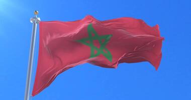 Flag of Morocco waving at wind in slow in blue sky, loop video