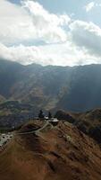 Majestic Monastery in Mountainous Landscape A breathtaking view of a serene monastery perched on a hill, framed by stunning peaks and a quaint village nestled in the valley below video