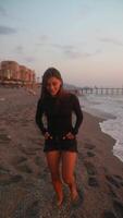 A Young Woman Who Is Enjoying a Relaxing Moment at the Beach During a Beautiful Sunset video