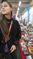 A Curious Shopper Exploring a Vibrant Market Stall Full of Unique and Colorful Items video