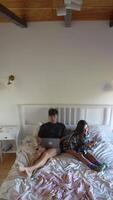 Enjoying a cozy and comfortable morning lounging in bed while engaging with technology, video
