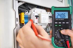 Technician Testing Voltage with Digital Multimeter photo