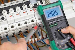 Electrician Testing Voltage in Circuit Breaker System with Multimeter photo