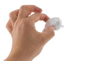 A close up of a hand holding a white electrical plug against a white background symbolizing power and connectivity photo