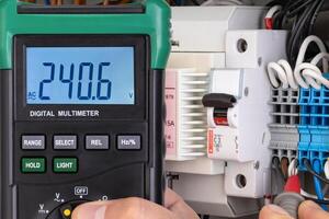 Voltage Measurement with Digital Multimeter in Electrical Panel photo