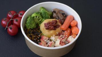 Boiled beef with vegetables, grains, seeds and spices in a ceramic plate on a dark concrete background video