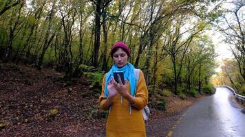 Woman with Backpack Using Smartphone, Hiking In The Forest And Typing Message On Smartphone. Solo female hiker using smart phone. Female hiker takes smart phone pic of mountains and forest. video