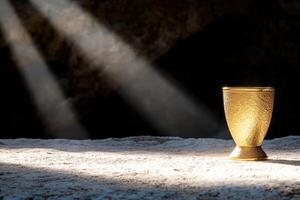 Glowing golden chalice in dark moody atmosphere photo
