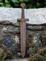 Rustic medieval sword embedded in stone photo