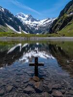 Serene mountain landscape with cross reflection photo