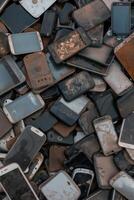 Pile of old and damaged mobile phones and electronic devices photo