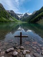 Serene mountain lake with wooden cross photo