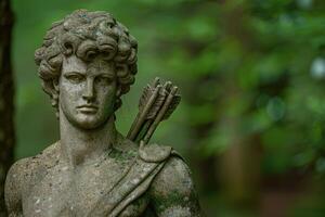 Weathered stone statue of a mythological figure with a bow and arrow photo