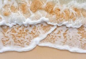 Closeup of foaming ocean waves on sandy beach photo