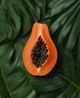 Tropical papaya fruit cross section on lush green leaves photo